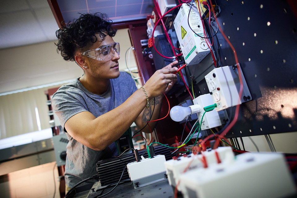 Hispanic male student working on wires