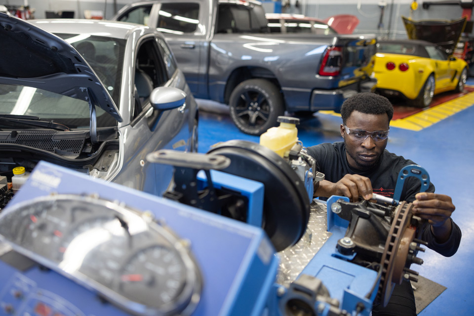 Black auto student working on brake system