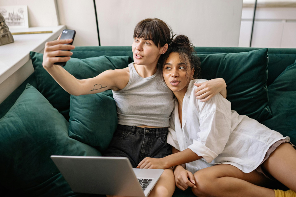 Two women taking a selfie on a sofa