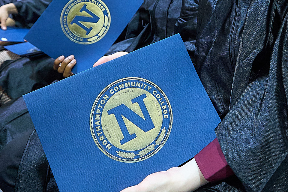 Blue folders holding grad diplomas