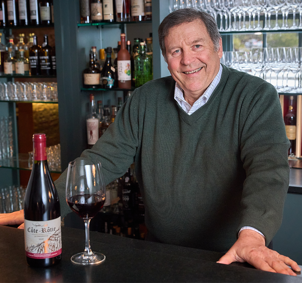 Chris Cree standing at bar with wine next to him
